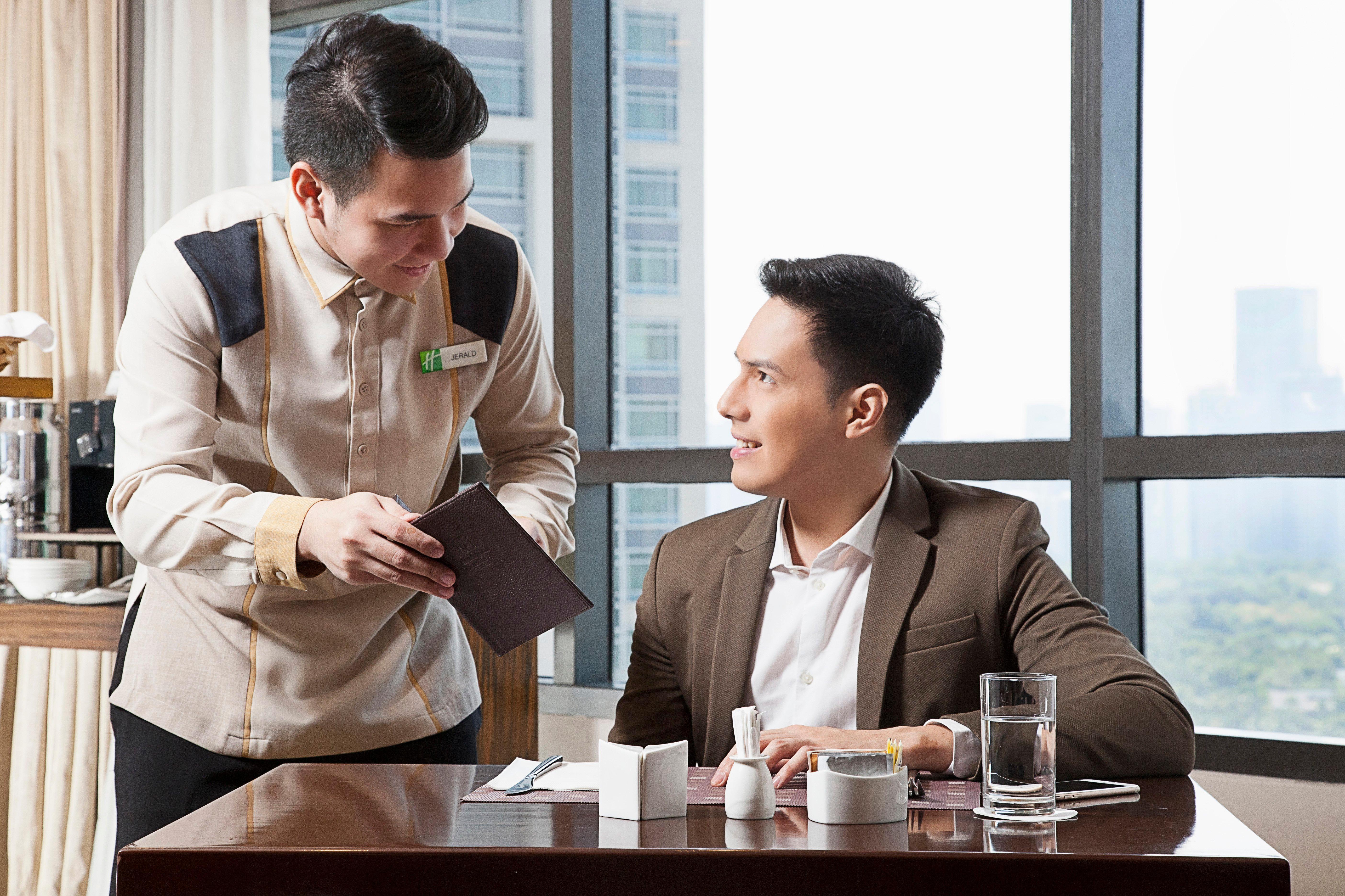فندق هوليداي إن آند سويتس ماكاتي المظهر الخارجي الصورة A butler serving a guest
